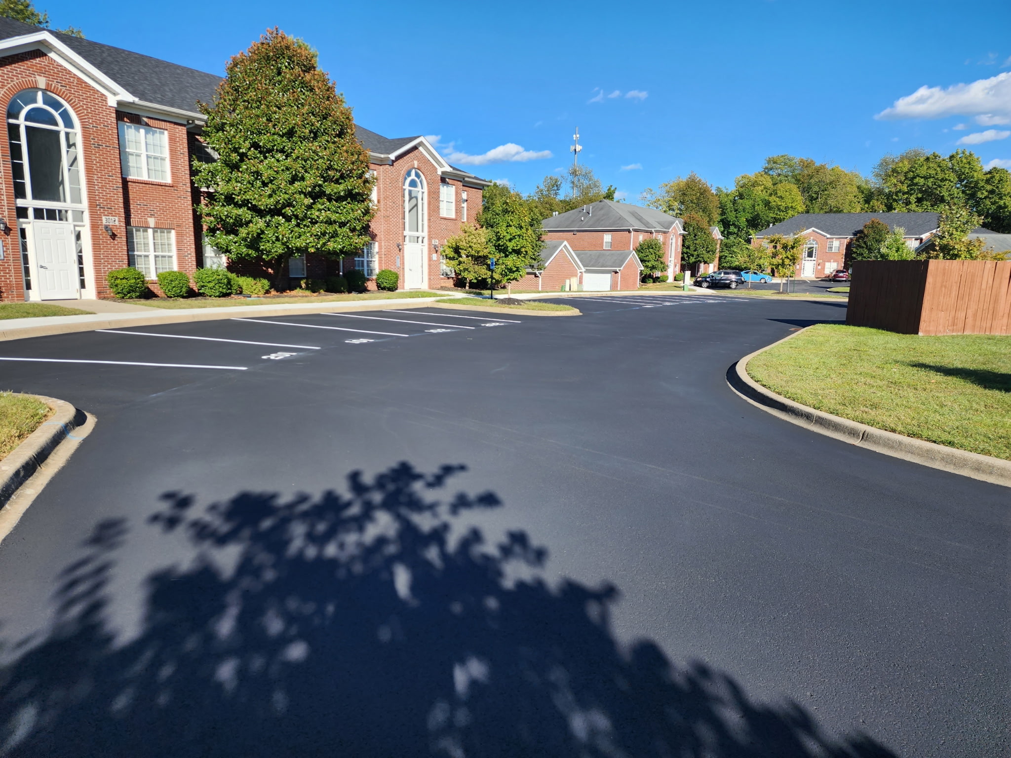 Freshly sealcoated commercial parking lot with crisp striping